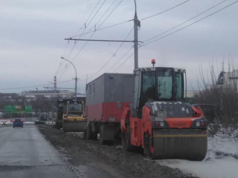 Дорожники продолжают укладывать асфальт в снег в Новосибирске